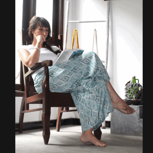 Femme assise, allure décontractée, sport-chic, vêtue d'un pantalon fluide en coton léger