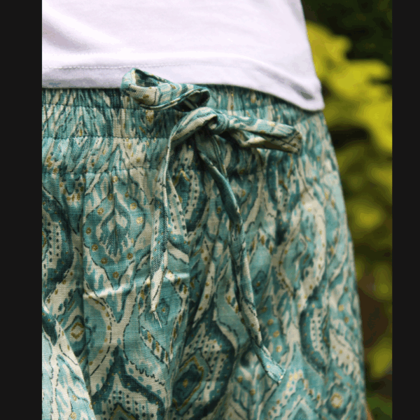 Gros plan sur un pantalon taille élastiquée en coton léger bleu turquoise imprimé style indien, parfait pour tenue relax et élégante