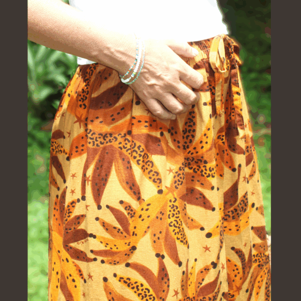 Gros plan sur la texture du lin imprimé. Pantalon fluide, montrant le confort et la qualité du tissu respirant.