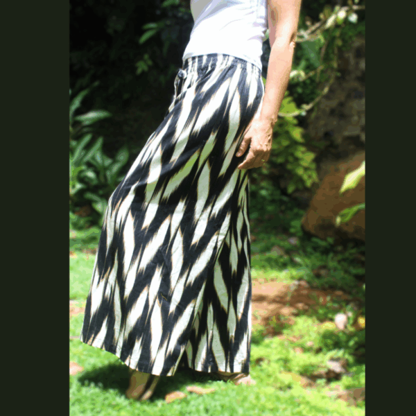 Pantalon fluide lin noir blanc femme, ceinture élastiquée, look sport chic. Vue de profil