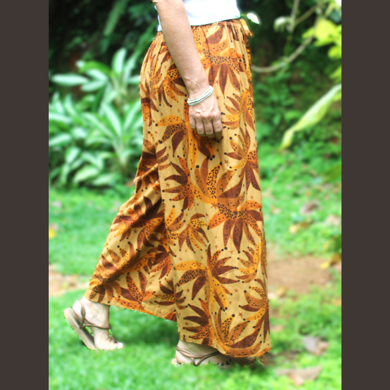 Pantalon fluide en lin tons chauds montrant le motif tropical et la matière légère et respirante. Taille unique (36-38)