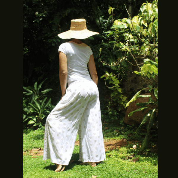 Pantalon fluide coton blanc motifs dorés porté de dos, tombé élégant