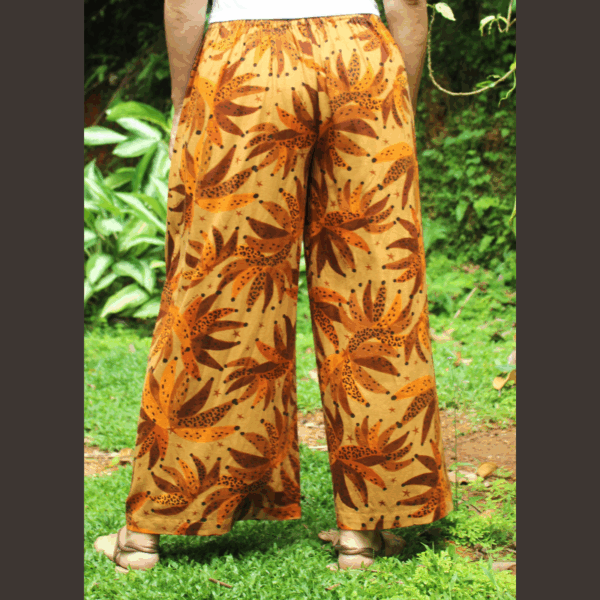Vue de dos du pantalon fluide en lin imprimé tropical sur une femme, mettant en évidence la coupe parfaite, la taille élastique et le style décontracté chic