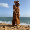 Femme portant une robe longue en lin et un sac parfaitement coordonné en macramé, un ensemble aux couleurs chaudes et lumineuses